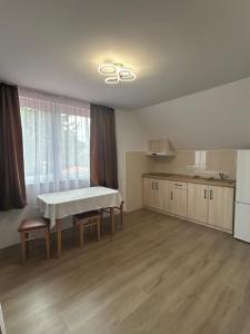 an empty room with a table and a kitchen at PENSIUNEA KELEMEN in Praid
