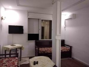 a small room with two beds and a mirror at Appartement Ezzdine sfaxi in Kelibia