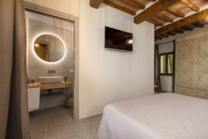 a bathroom with a bed and a sink and a mirror at Casa Costarella - San Gimignano in San Gimignano