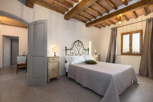 a bedroom with a large bed and a wooden ceiling at Casa Costarella - San Gimignano in San Gimignano