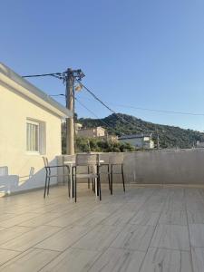 a patio with a table and chairs on a roof at One floor of house in Bar