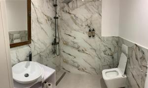 a white bathroom with a sink and a toilet at Milo's Villa in Dhërmi +28 photos