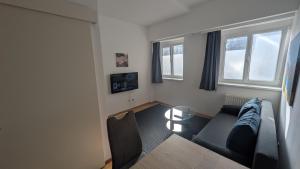 a living room with a couch and two windows at Tor zur Weinstrasse, Smart & Einfach in Leibnitz