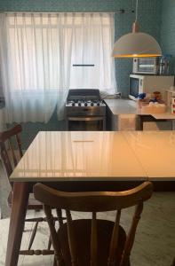 a kitchen with a wooden table and a stove at Casa com 2 quartos Mobiliada próxima ao Batel e Parque Barigui in Curitiba +5 photos