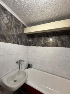a bathroom with a sink and a bath tub at Apkalna Retro Apartment in Ventspils