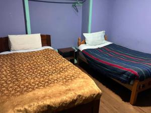 two beds in a room with purple walls at Imperio Carlos V in Oruro