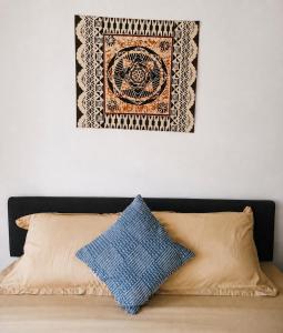 a picture hanging above a bed with two pillows at Nadi Airport Bed & Breakfast in Nadi