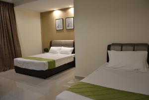 duas camas num pequeno quarto com duas camas sidx sidx em The Baiti em Bandar  Pusat Jengka