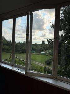 an open window with a view of a field at Apkalna Retro Apartment in Ventspils