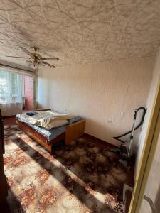 an empty room with a bed and a ceiling at Apkalna Retro Apartment in Ventspils