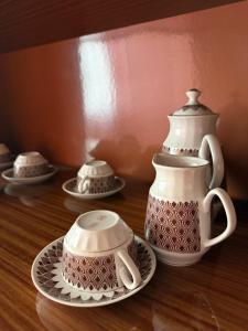 a group of tea sets on a wooden table at Apkalna Retro Apartment in Ventspils