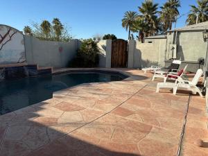 a patio with a pool and chairs and a fence at CRYStALZ pool studio kitchen DWNtWN stadiums arts in Phoenix