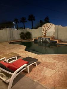 a swimming pool with a chaise lounger in front of a pool at CRYStALZ pool studio kitchen DWNtWN stadiums arts in Phoenix