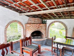 a room with a brick fireplace with a table and chairs at Sitio Viração in Bonito