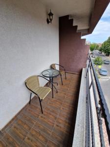 a balcony with two chairs and a table at Harmony Rooms & Studios in Constanţa