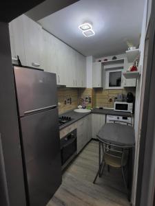 a kitchen with a stainless steel refrigerator and a table at Apartament Cristian Relax in Olimp