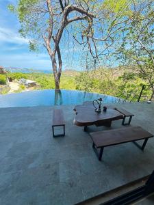 a picnic table and a bench on a patio at Villa Green Diamond in Playa Flamingo