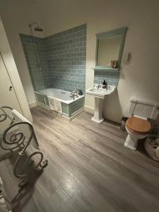 a bathroom with a tub and a toilet and a sink at Newton Farmhouse B & B in Jedburgh