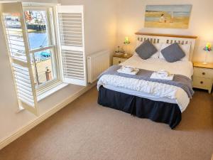 a bedroom with a bed and a large window at Whitby Sea View Cottage Prime Historic Old Town Location in Whitby