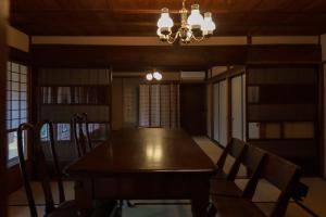 a dining room with a wooden table and chairs at Tokyo Sake House in Ome