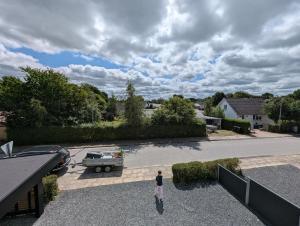 a person standing on a patio with a boat in a driveway at Kølkær B&B in Kølkær