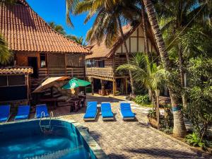 ein Resort mit Swimmingpool und blauen Liegestühlen in der Unterkunft La Posada in Máncora