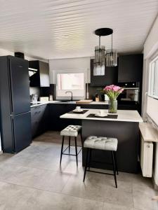 a kitchen with black cabinets and a kitchen island with stools at Apartment Prinz Luis in Owingen