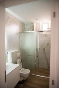a bathroom with a shower and a toilet and a sink at Hersol Skyline in Durrës +32 photos