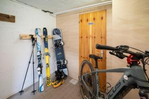 a bike parked in a room with skis and skis at Césa Marta in Canazei