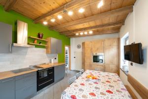 a kitchen with green walls and wooden ceilings at Césa Marta in Canazei