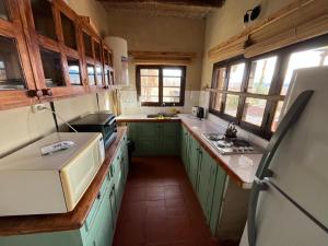eine Küche mit grünen Schränken und einem weißen Kühlschrank in der Unterkunft Finca Basin in Barreal + 9 Fotos