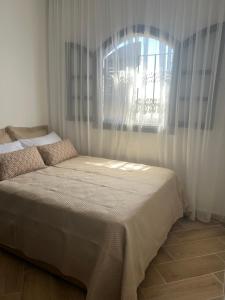 a bed in a room with a window at Casa Mouna in Cabo Negro