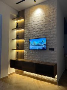 a living room with a tv on a brick wall at Casa Mouna in Cabo Negro