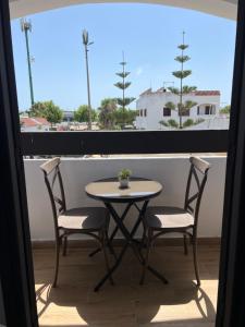 a table and two chairs on a balcony with a window at Casa Mouna in Cabo Negro