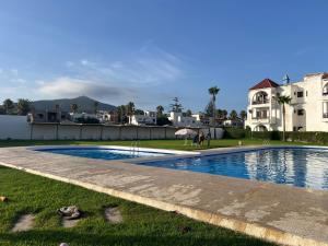 a swimming pool in a yard with a house in the background at Casa Mouna in Cabo Negro