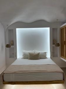 a bedroom with a large bed with a white headboard at Pyrgianos Suites - Private Jacuzzi in Glinado Naxos