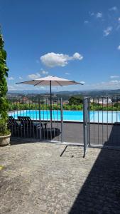 a white umbrella sitting next to a swimming pool at Quinta de Basto House in Felgueiras