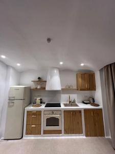 a kitchen with a white refrigerator and a sink at Pyrgianos Suites - Private Jacuzzi in Glinado Naxos +2 photos