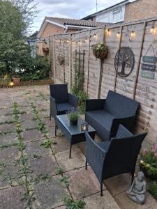 a patio with chairs and a table and a fence at Large river side house, parking,for 9 people in Bedford