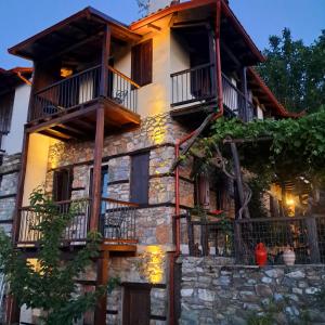 an old stone house with balconies on it at Nykteri Heritage House Olympus & Sea View in Palaios Panteleimonas