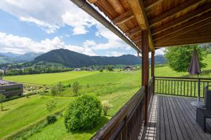 a wooden porch with a view of a green field at "schön-urlauben" in Gröbming