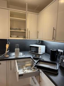 a kitchen with white cabinets and a stove top oven at Central 2 bed large apt M1 area in Manchester
