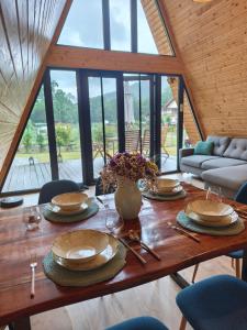 a wooden table with plates and a vase of flowers on it at Transylvantures Cabin in Rimetea