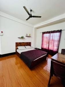 a bedroom with a bed and a ceiling fan at The Quiet Lantern Homestay in Sibsāgar