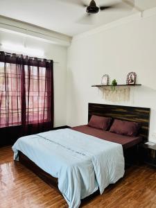 a bedroom with a large bed and two windows at The Quiet Lantern Homestay in Sibsāgar