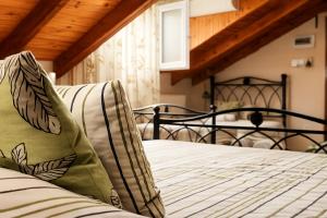 a bedroom with a bed with a green pillow on it at Filyra Pension in Nafplio +59 photos