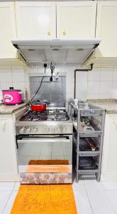 a kitchen with a stove top oven in a kitchen at TIDY Premium Hostel, Sharjah in Sharjah