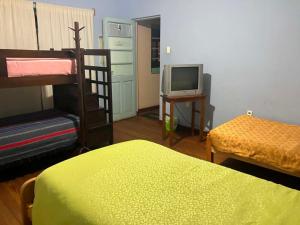 a bedroom with a bunk bed and a television at Imperio Carlos V in Oruro +1 photo