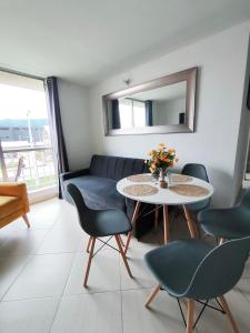 a living room with a table and chairs and a mirror at Faro 2 Loft Jaime Duque, Autódromo Tocancipá in Tocancipá