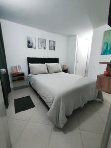 a white bedroom with a large bed in it at Faro 2 Loft Jaime Duque, Autódromo Tocancipá in Tocancipá